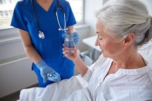 old patient with nurse with pills in hand